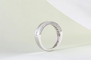 Close-up of an elegant silver ring adorned with diamonds on a minimalist background, perfect for luxury jewelry themes.